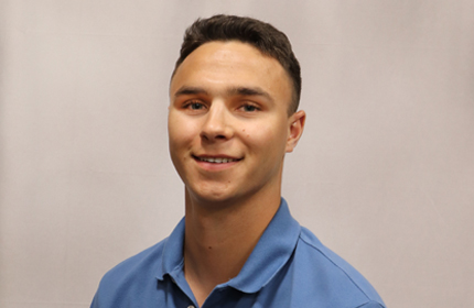 Young male headshot wearing a blue button-down